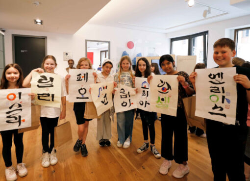Eine Schülergruppe freut sich über als Geschenk überreichte Kalligrafien. - Foto: © Koreanisches Kulturzentrum