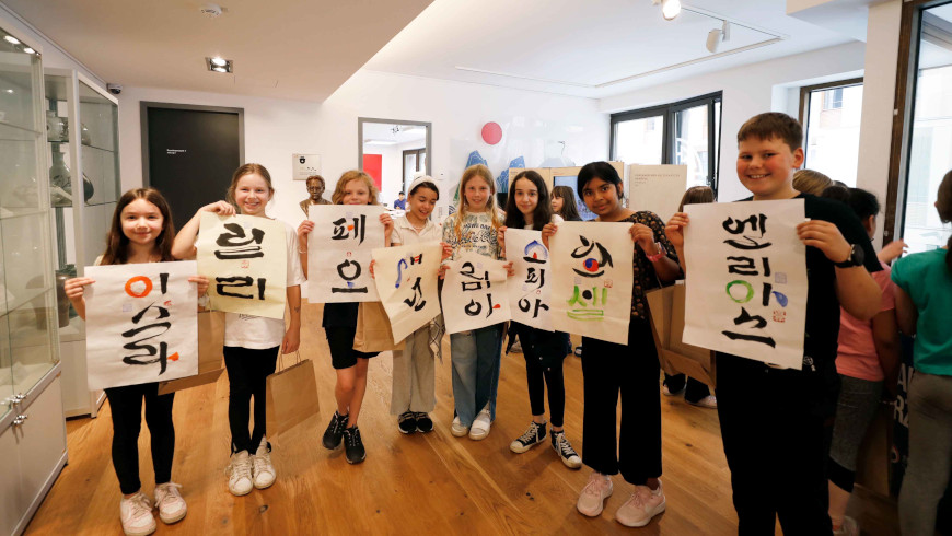 Eine Schülergruppe freut sich über als Geschenk überreichte Kalligrafien. - Foto: © Koreanisches Kulturzentrum